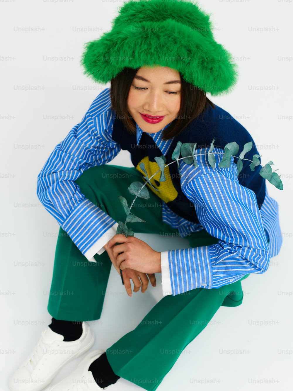 a woman wearing a green hat and green pants