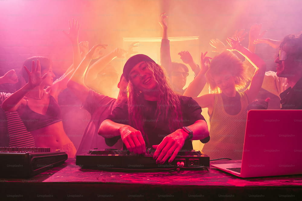 a dj mixing music in front of a crowd of people