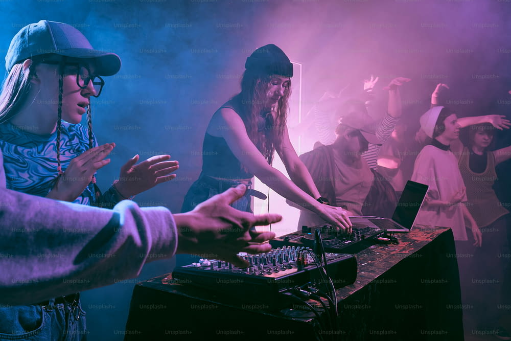 a group of people standing around a dj booth