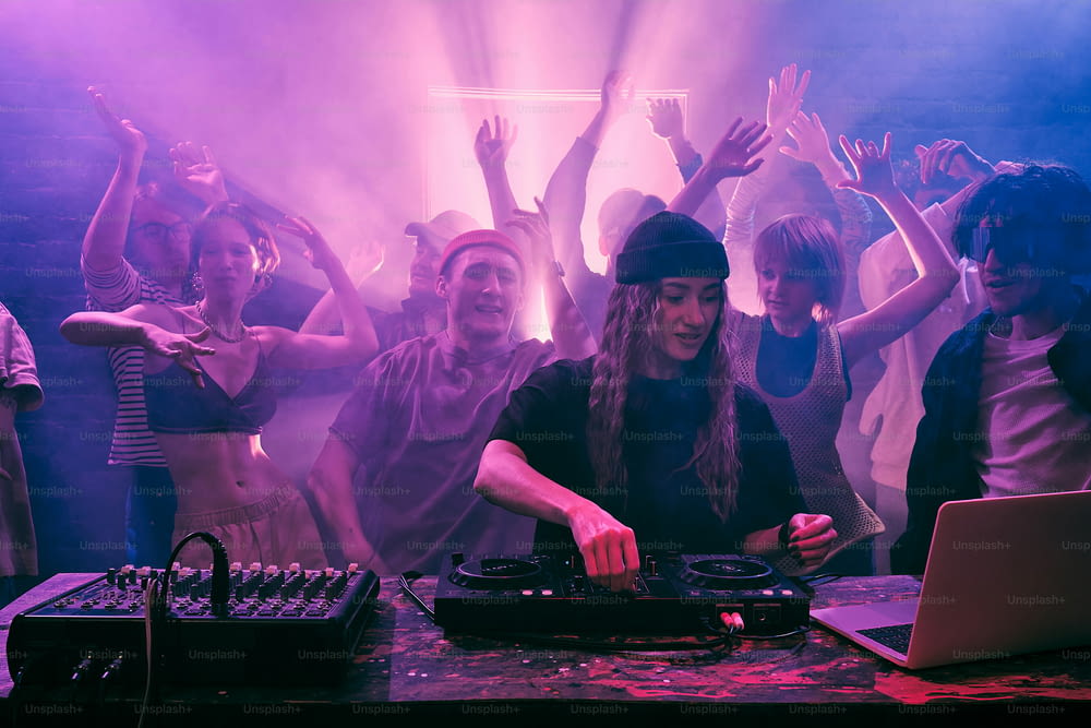 a dj mixing in front of a crowd of people