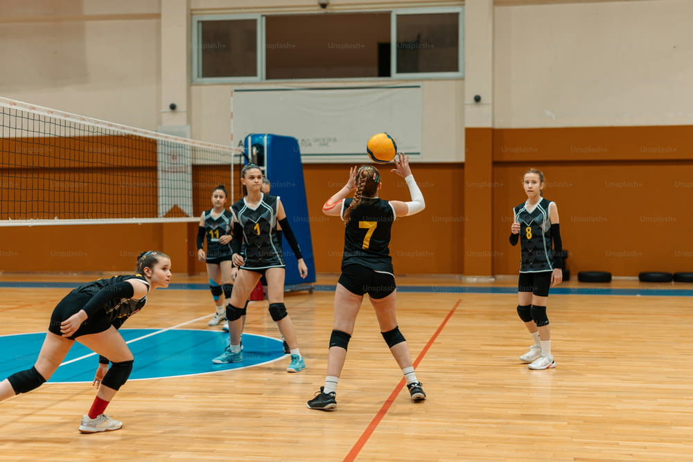 a group of young women playing a game of volleyball