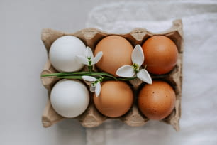 a carton filled with eggs and white flowers