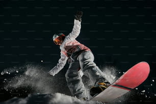 un homme faisant du snowboard sur une pente enneigée