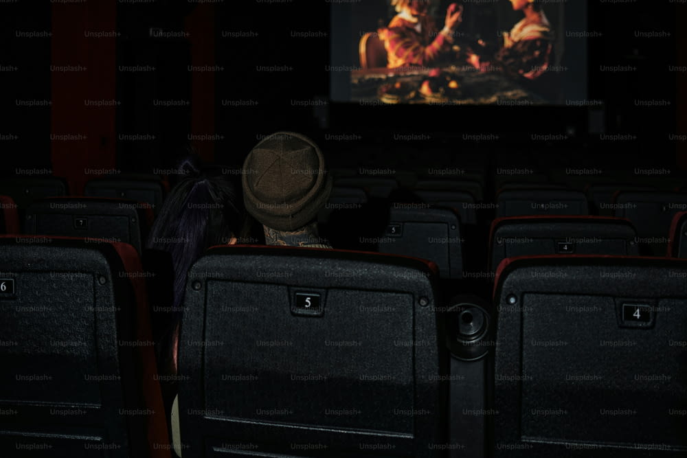 a person with a hat is watching a movie