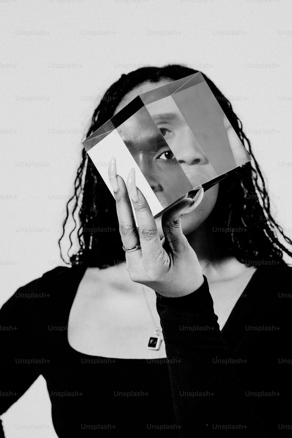 uma mulher segurando um pedaço de papel sobre o rosto