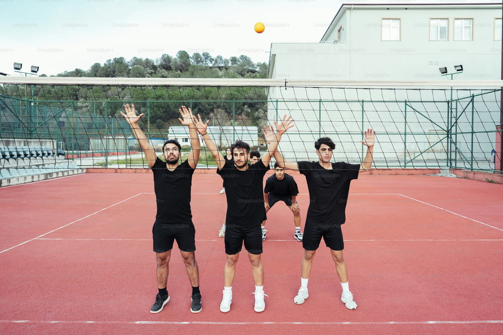 Eine Gruppe von Männern, die auf einem Tennisplatz stehen