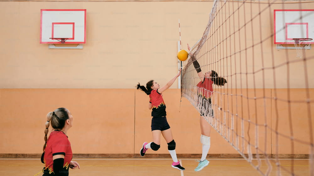 a group of young girls playing a game of volleyball