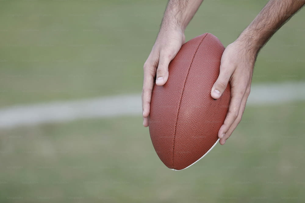 a close up of a person holding a football