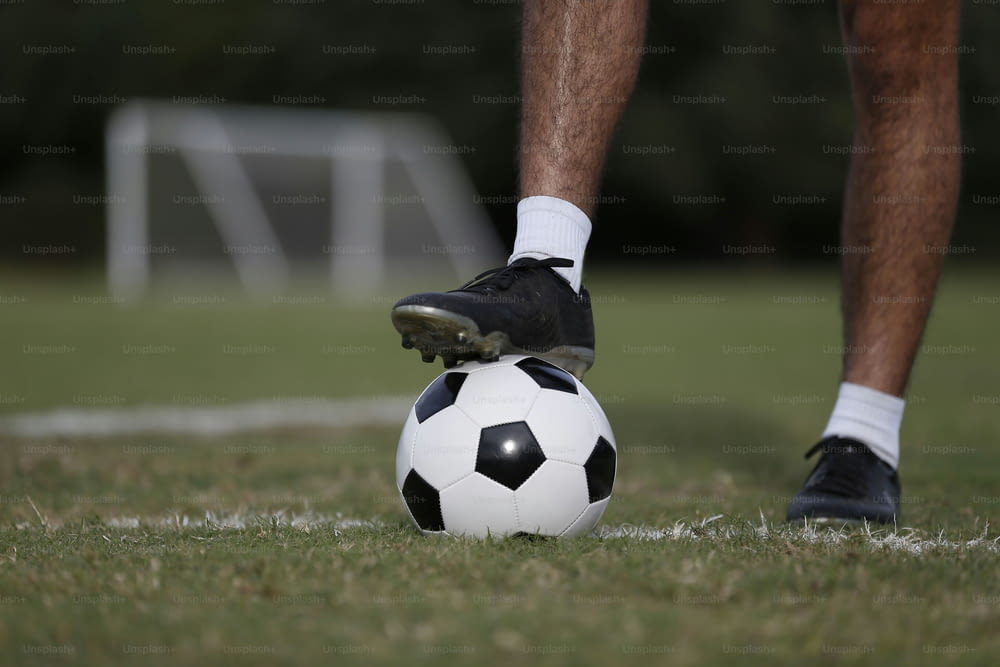 une personne debout sur un ballon de soccer sur un terrain