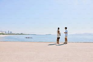 una coppia di uomini in piedi l'uno accanto all'altro su una spiaggia