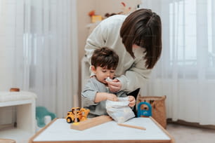 a woman is helping a small boy play with toys