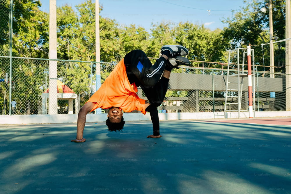 a person doing a handstand on a tennis court