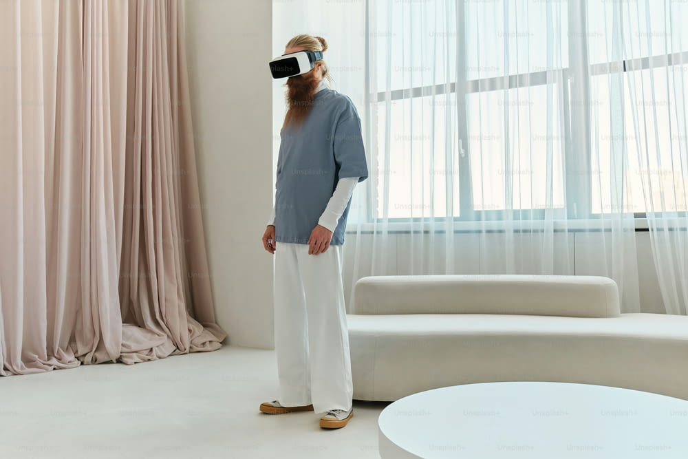 a man standing in front of a window wearing a virtual reality headset