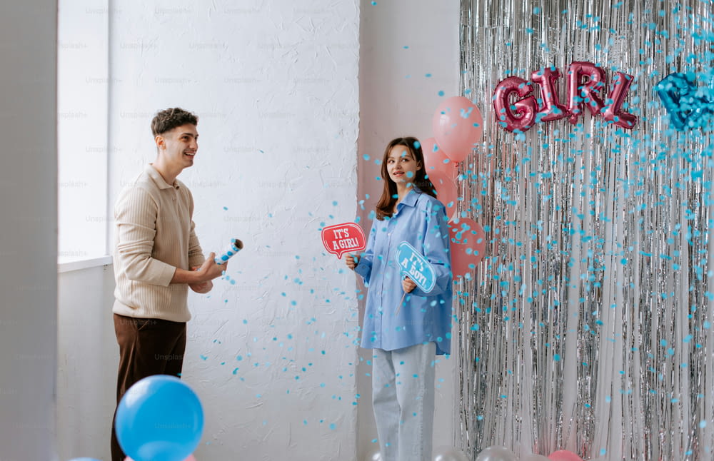 a man and a woman standing in front of balloons