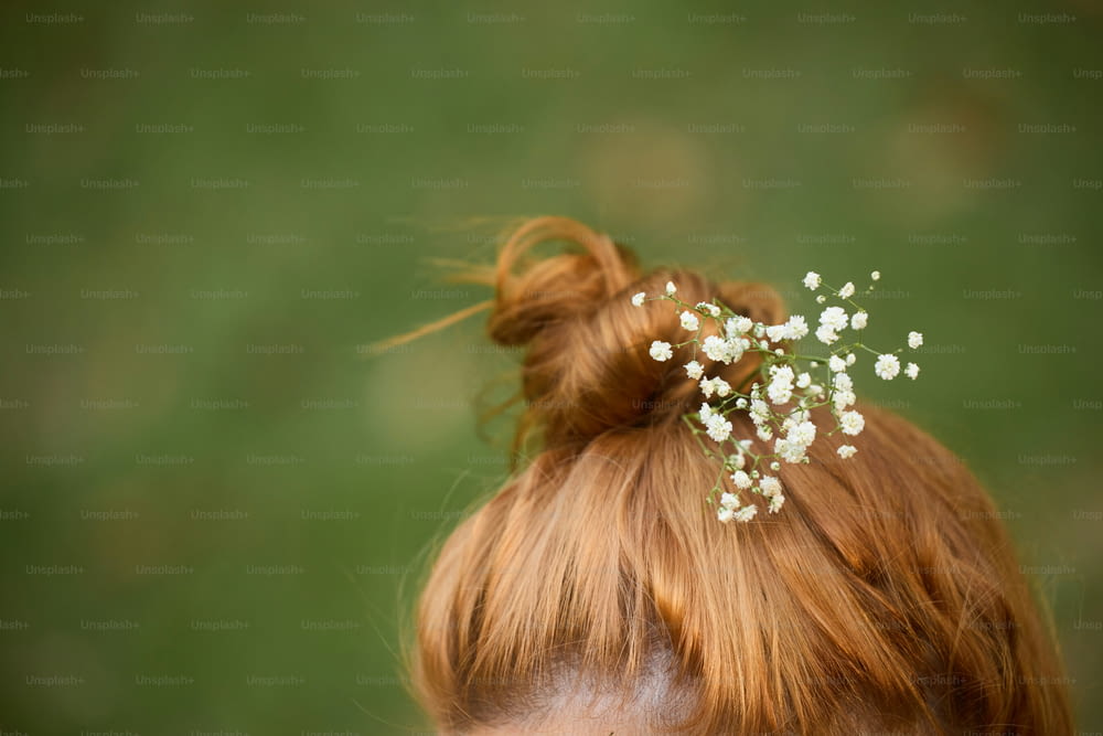 a close up of a woman with a flower in her hair