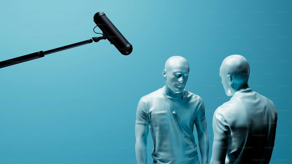 a microphone and two mannequins standing in front of a blue background