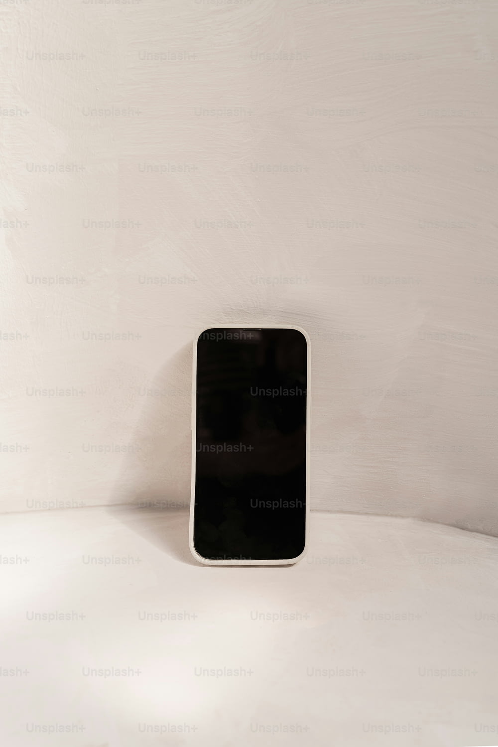 하얀 탁자 위에 놓인 검은색 휴대전화