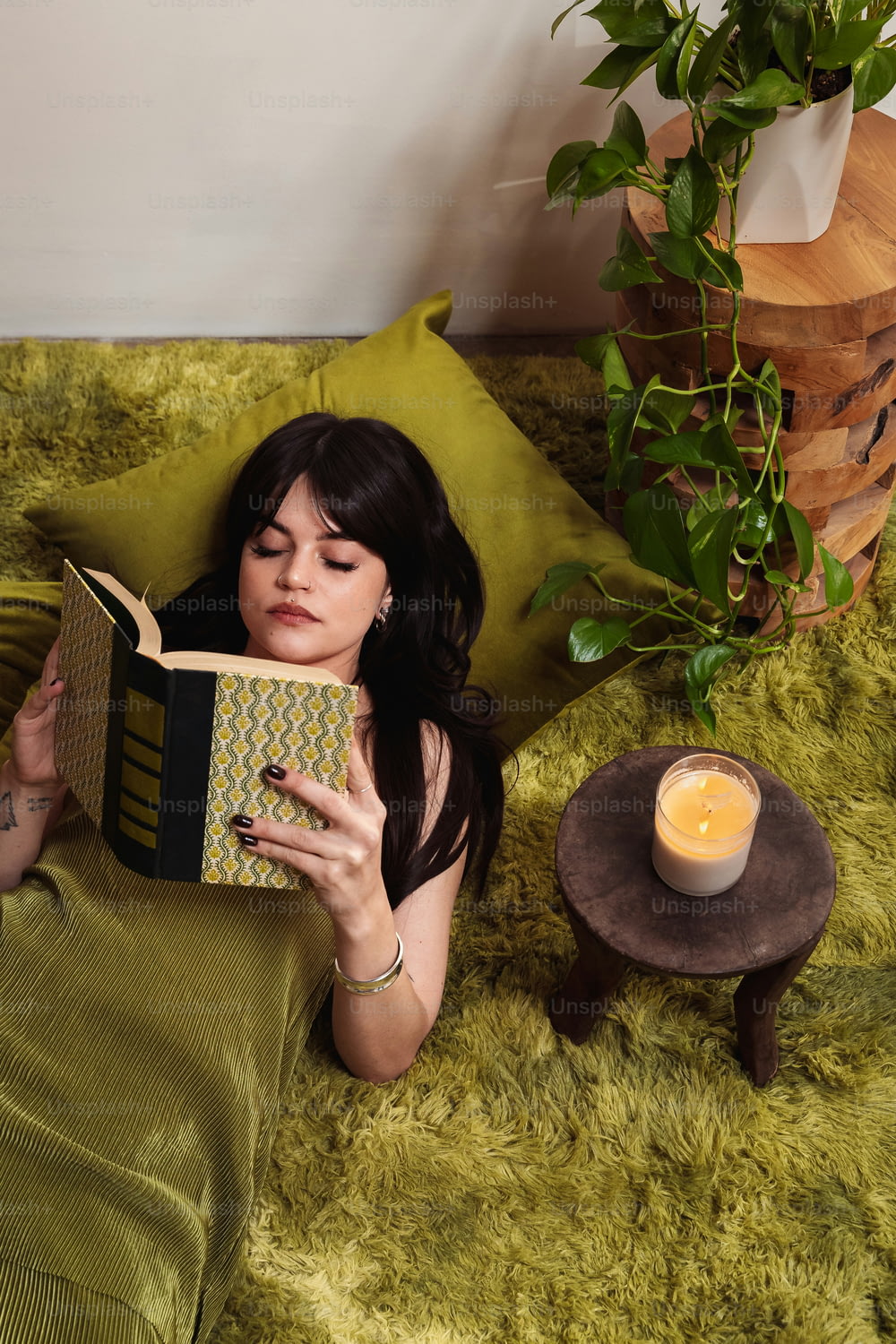eine Frau, die auf einem Bett liegt und ein Buch liest
