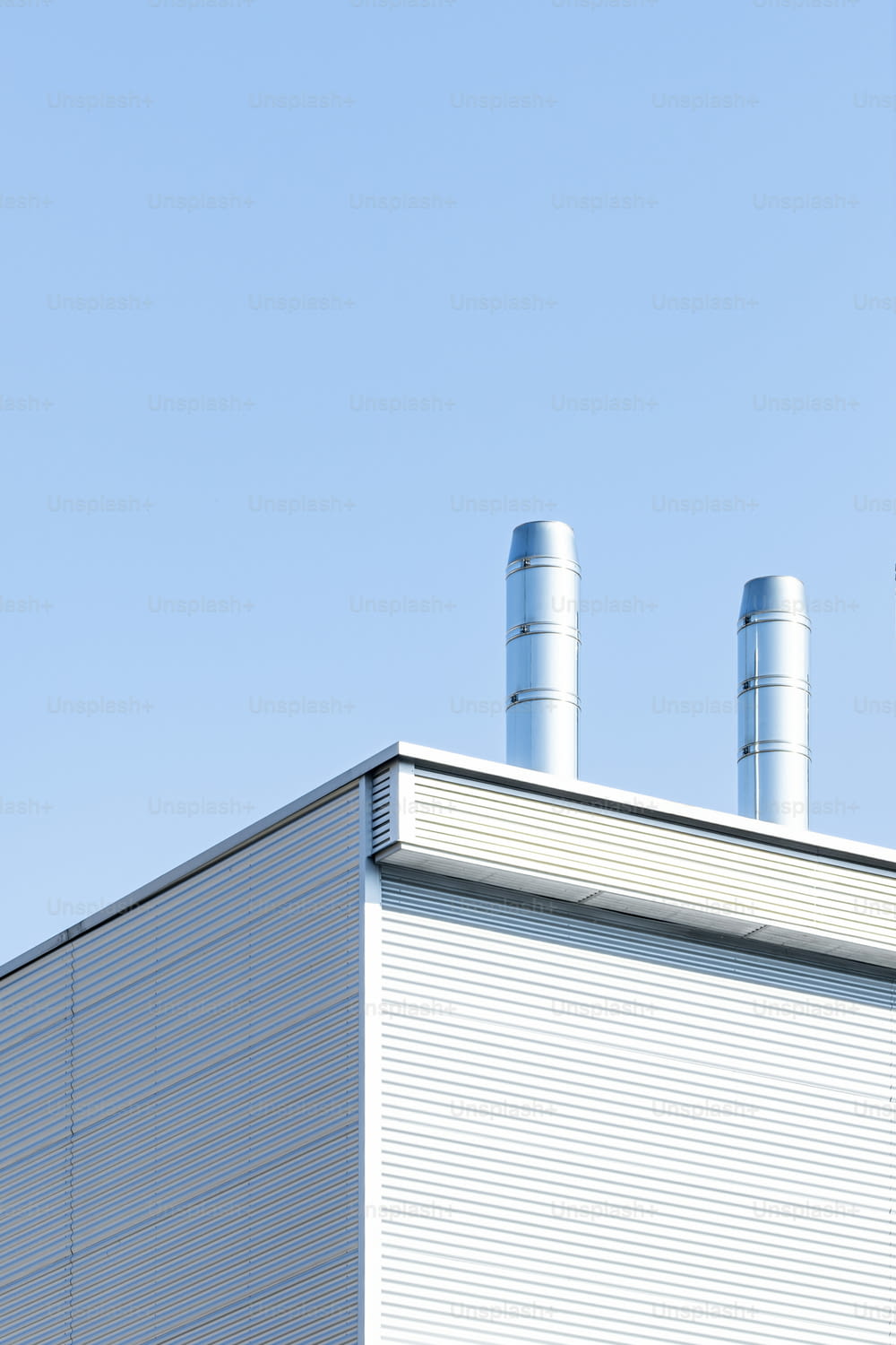 a white building with two blue smoke stacks on top of it