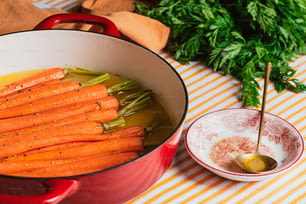 a pot filled with carrots next to a bowl of sauce