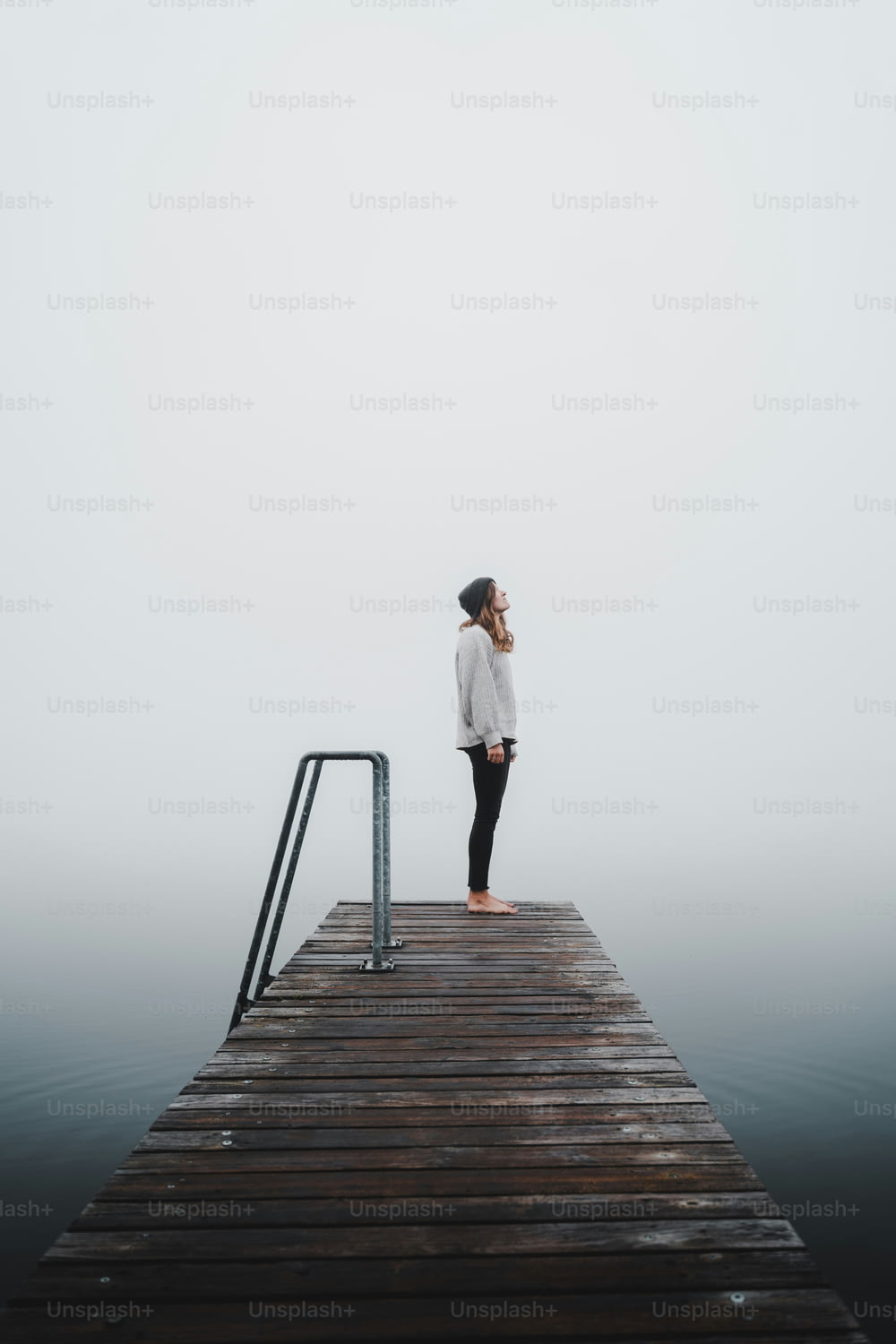 a person standing on a dock in the fog