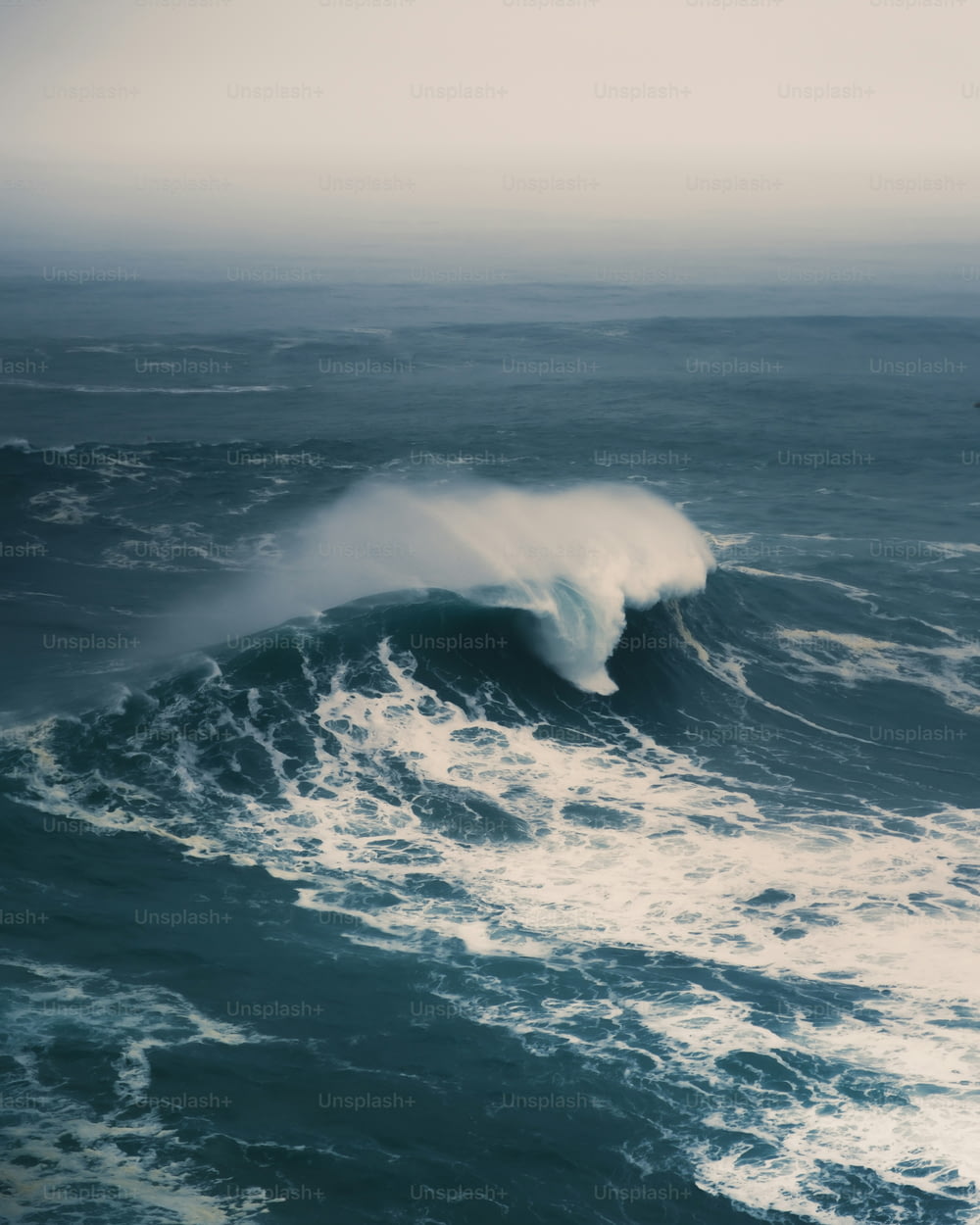 a large wave in the middle of the ocean