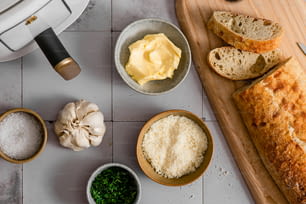 bread, butter, garlic, and other ingredients on a cutting board