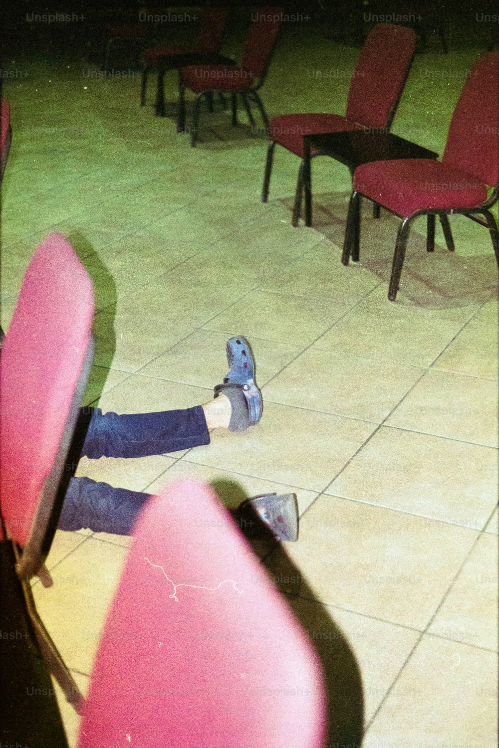 椅子に足を乗せて地面に横たわっている人