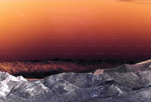 Blick auf eine Gebirgskette mit rotem Himmel im Hintergrund