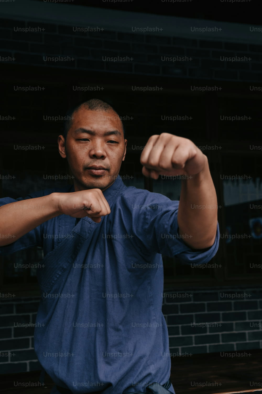 a man in a blue shirt flexing his muscles