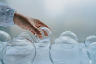 a hand is pouring water into a glass vase
