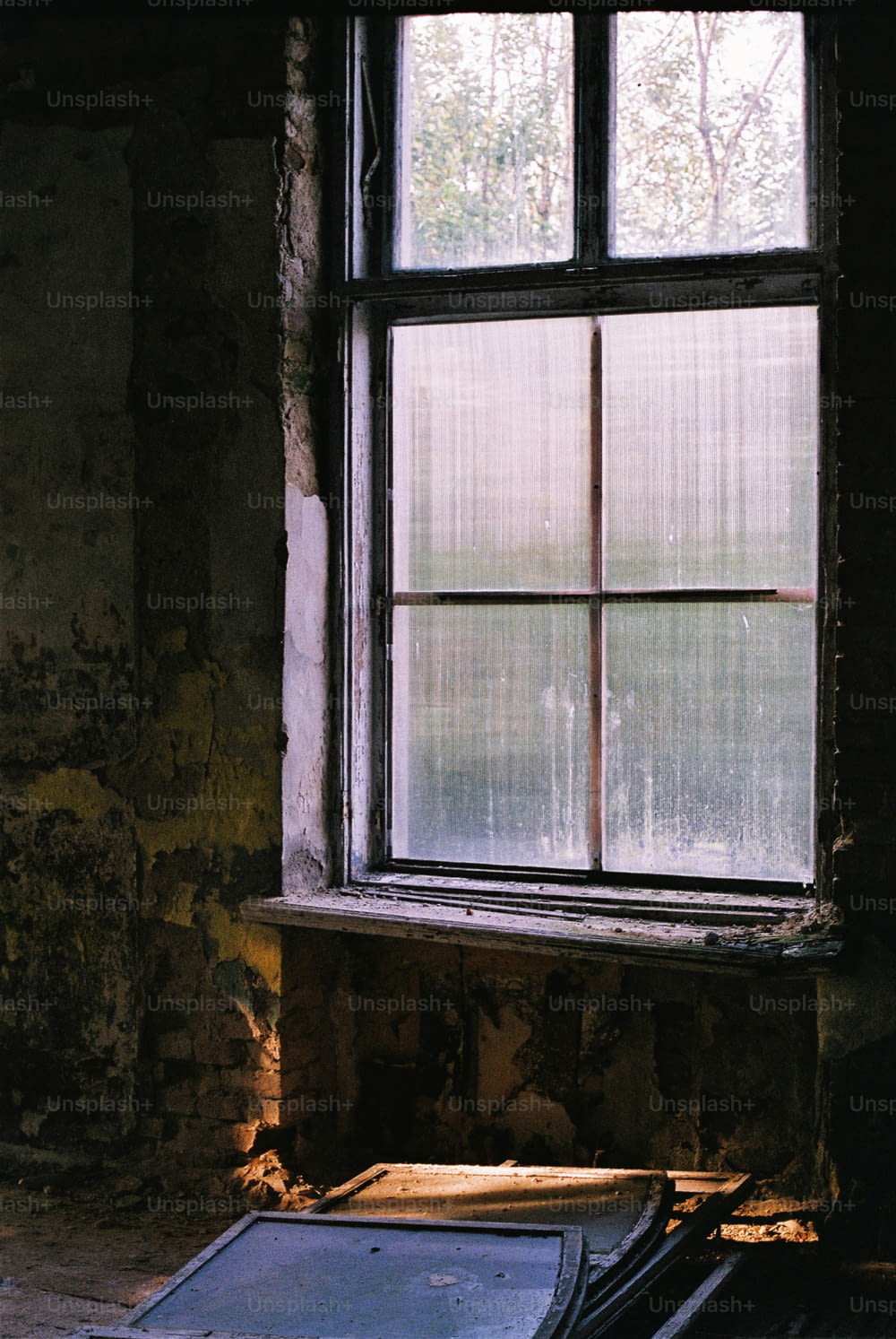 une fenêtre dans un immeuble délabré avec une vitre brisée
