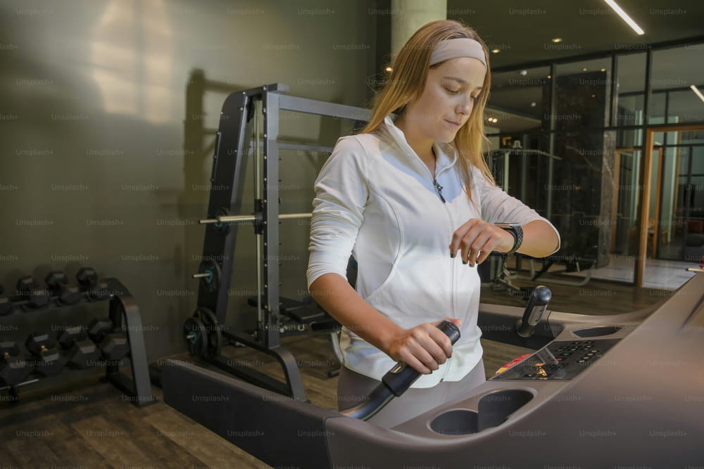 a woman is working on a machine in a gym