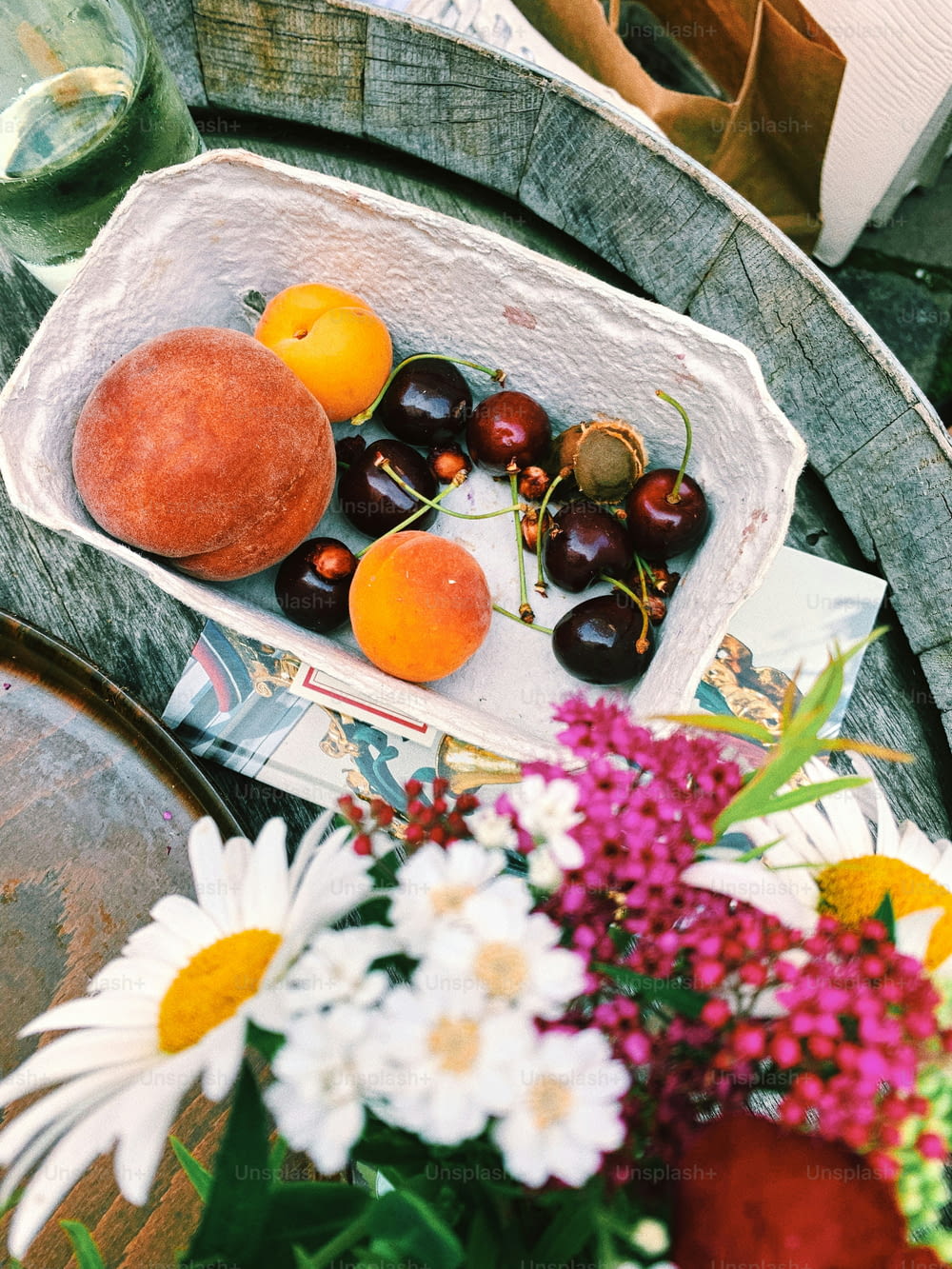 uma cesta cheia de cerejas e laranjas em cima de uma mesa