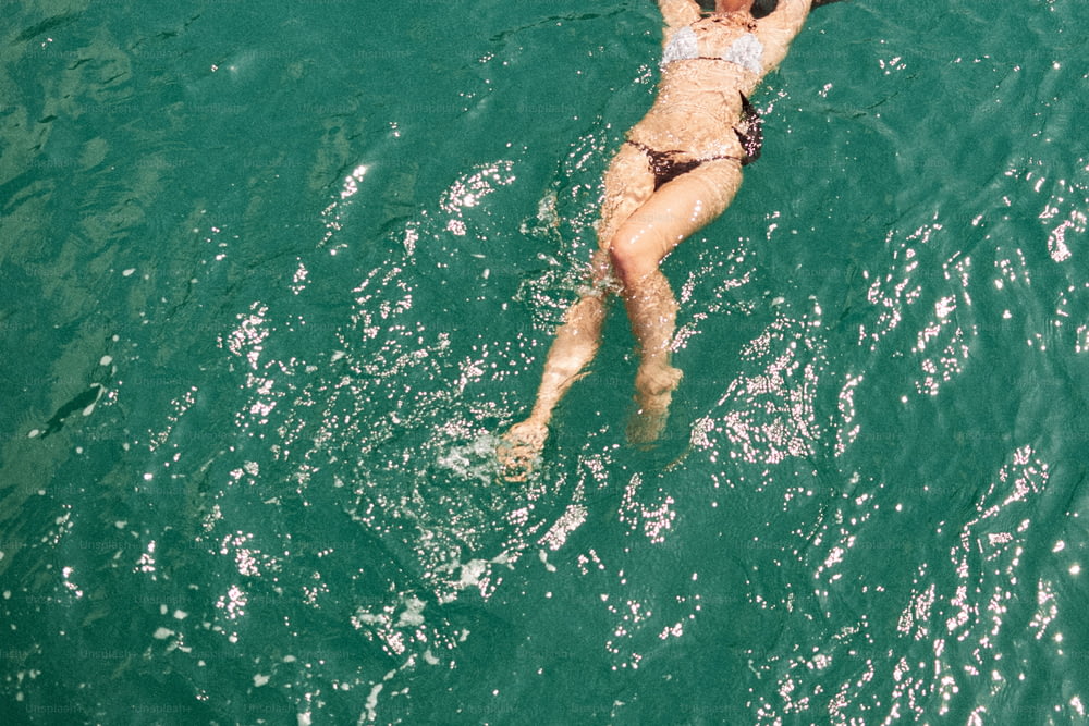 a woman in a bikini swimming in the ocean