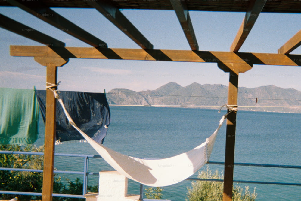 a white hammock hanging from a wooden structure
