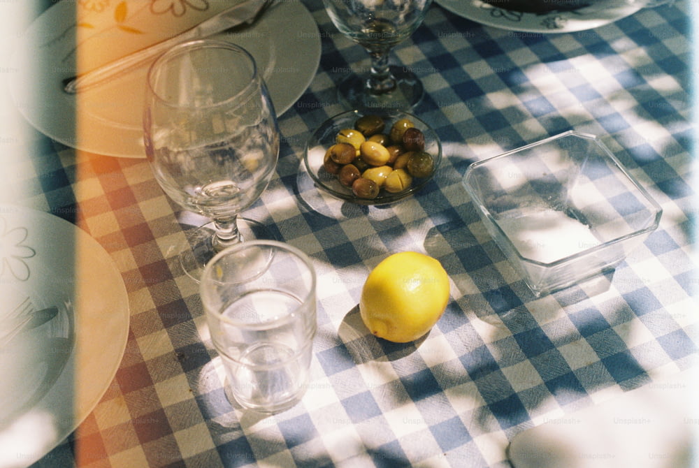Ein Tisch mit Tellern und Gläsern neben einer Zitrone