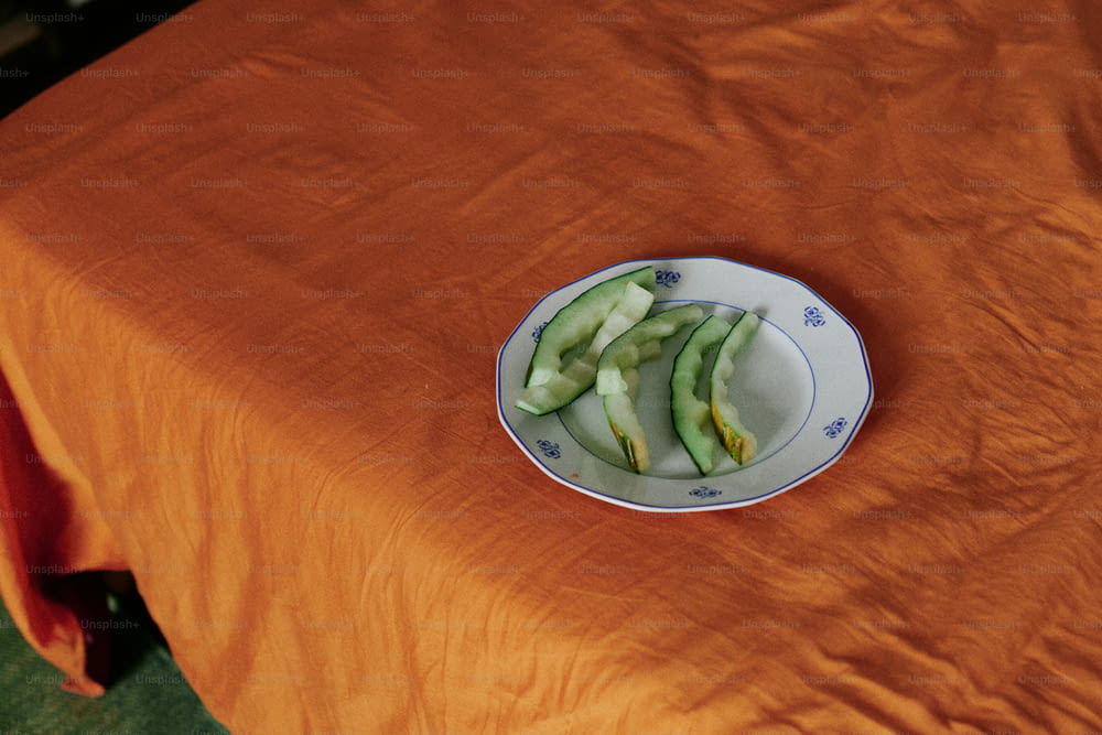 ein Teller mit geschnittenen Gurken auf einer orangefarbenen Tischdecke