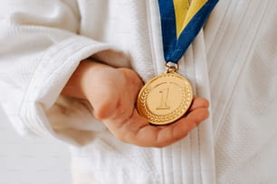 uma pessoa segurando uma medalha de ouro nas mãos