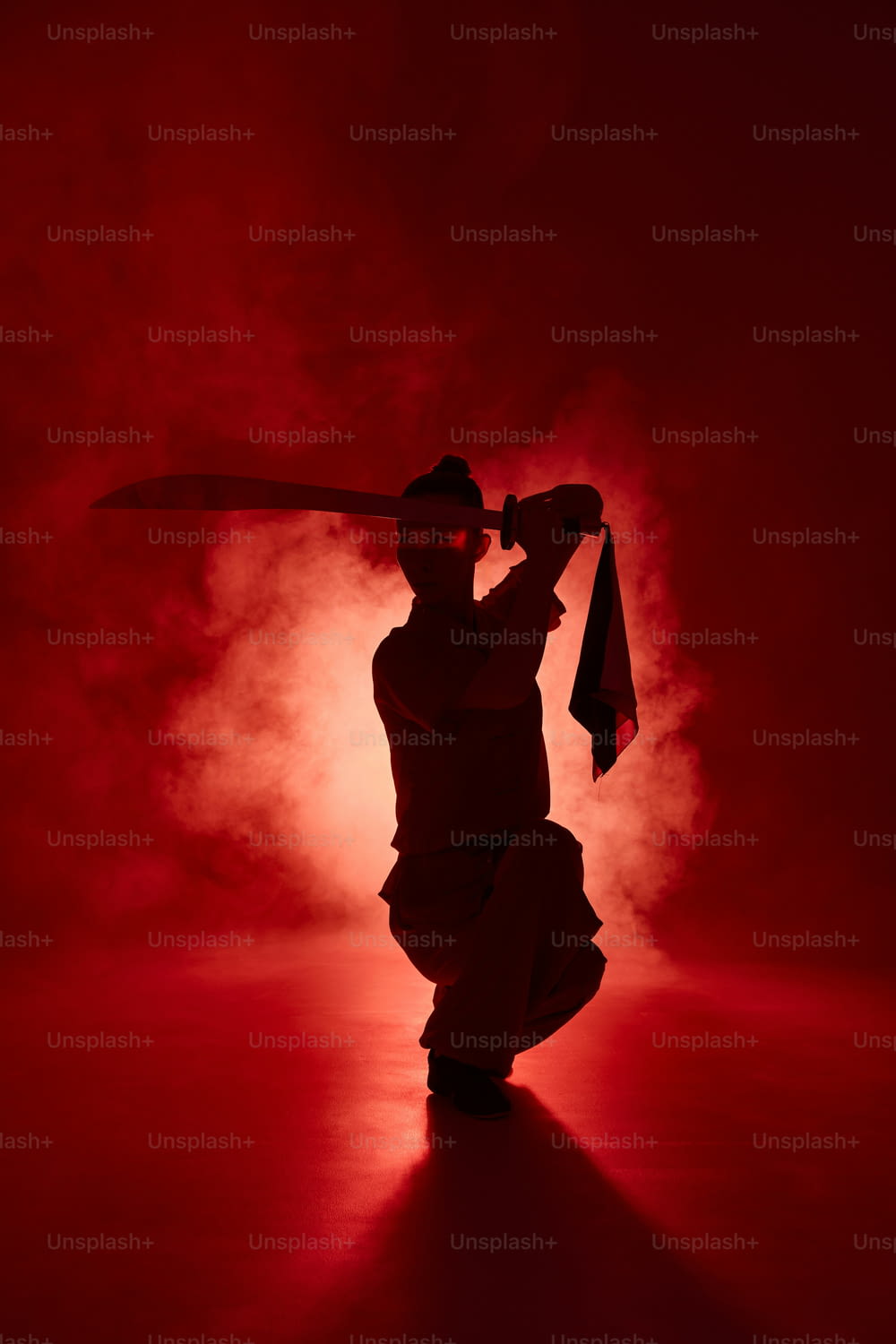 a person holding a large sword in a dark room