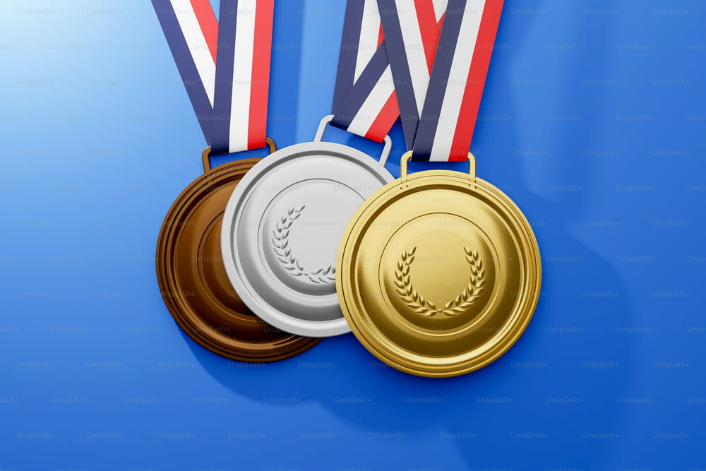 three gold, silver and bronze medals on a blue background