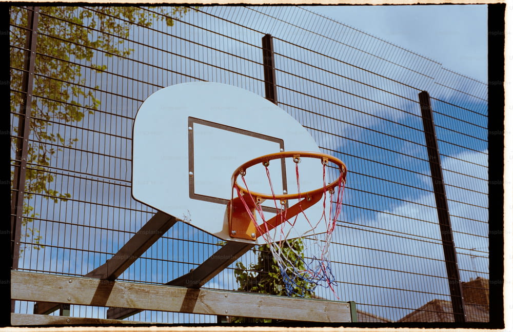 un panier de basket devant une clôture