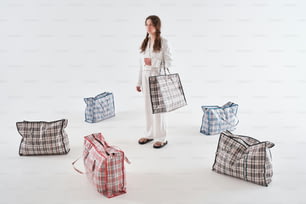 a woman standing in front of a bunch of bags