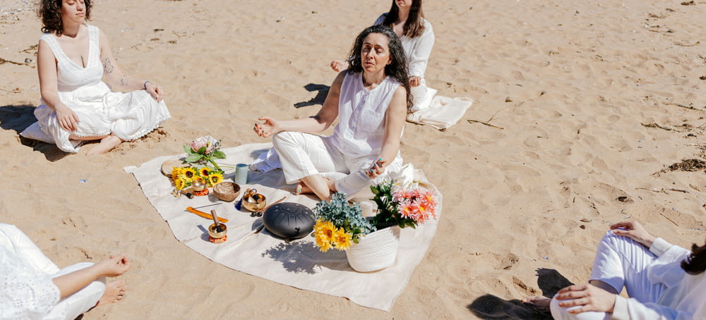 un groupe de femmes assises au sommet d’une plage de sable
