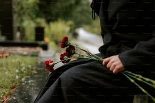 a person sitting on a bench with flowers