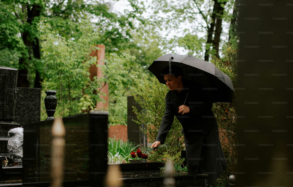 a woman holding an umbrella in a cemetery