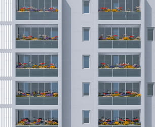a tall white building with a bunch of flowers on the balconies