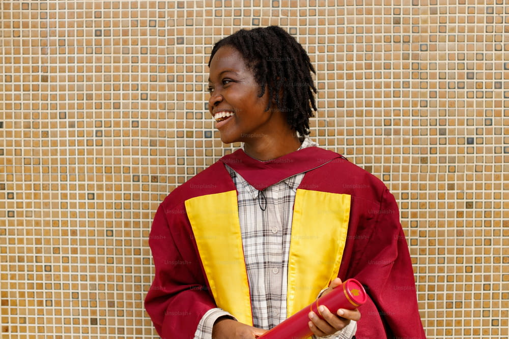 a woman in a red and yellow graduation gown