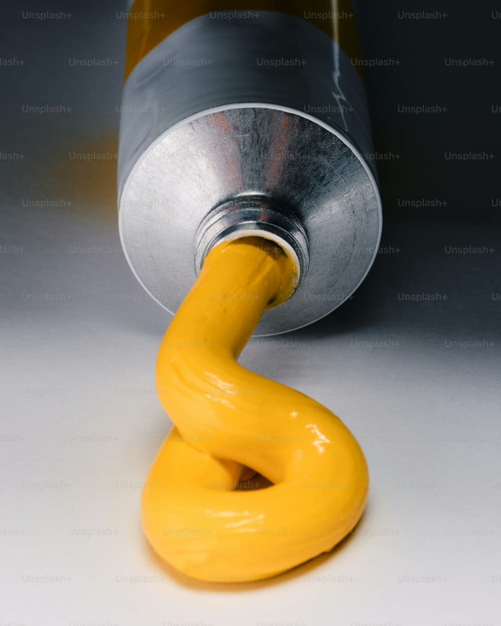 a metal can with a yellow handle on a white surface