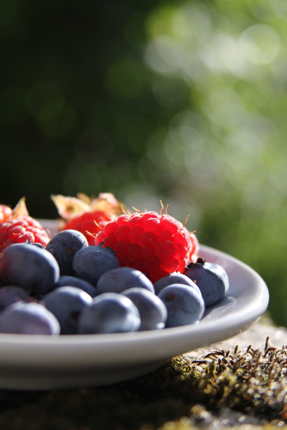 selective focus of blueberries and raspberries on bowl